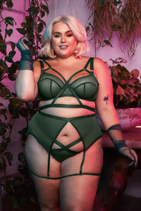 Green satin harness style bra seen with matching brief and suspender on Felicity Hayward.