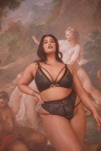model wears black wet look lace lingerie set with straps
