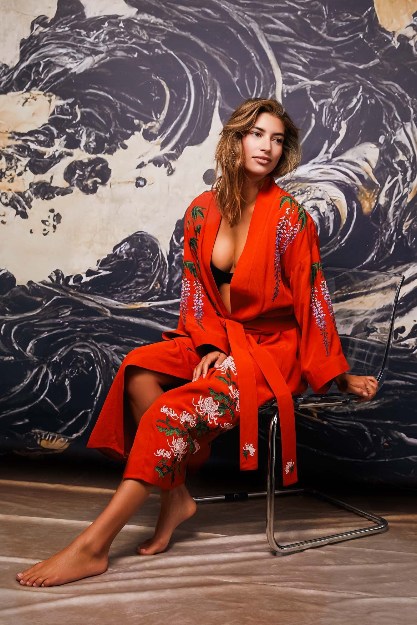 Model wears belted terracotta kimono robe embroidered with colourful wisteria and chrysanthemums styled over lingerie set