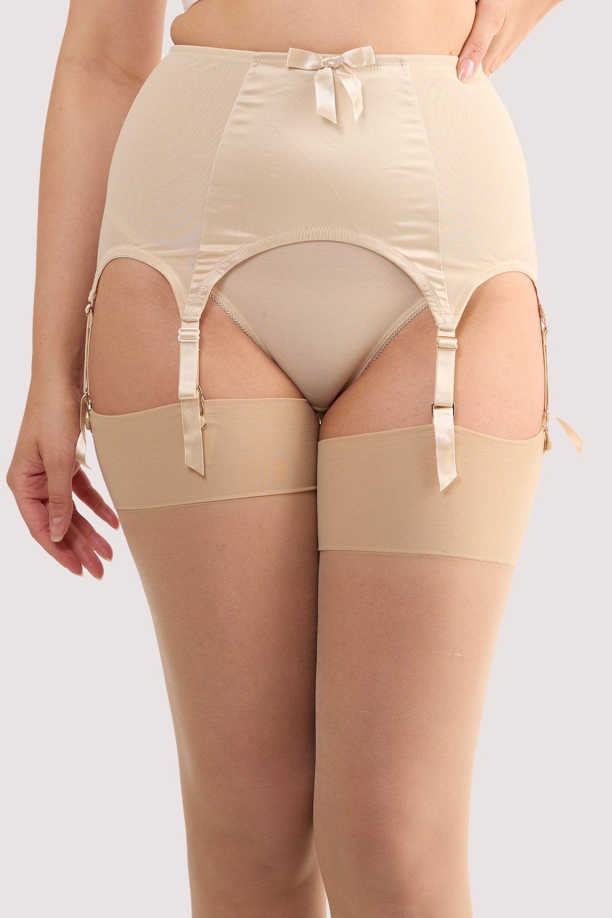 Model wears a champagne satin 6 strap retro everyday suspender with six adjustable straps, soft and smooth finish with a matching brief.