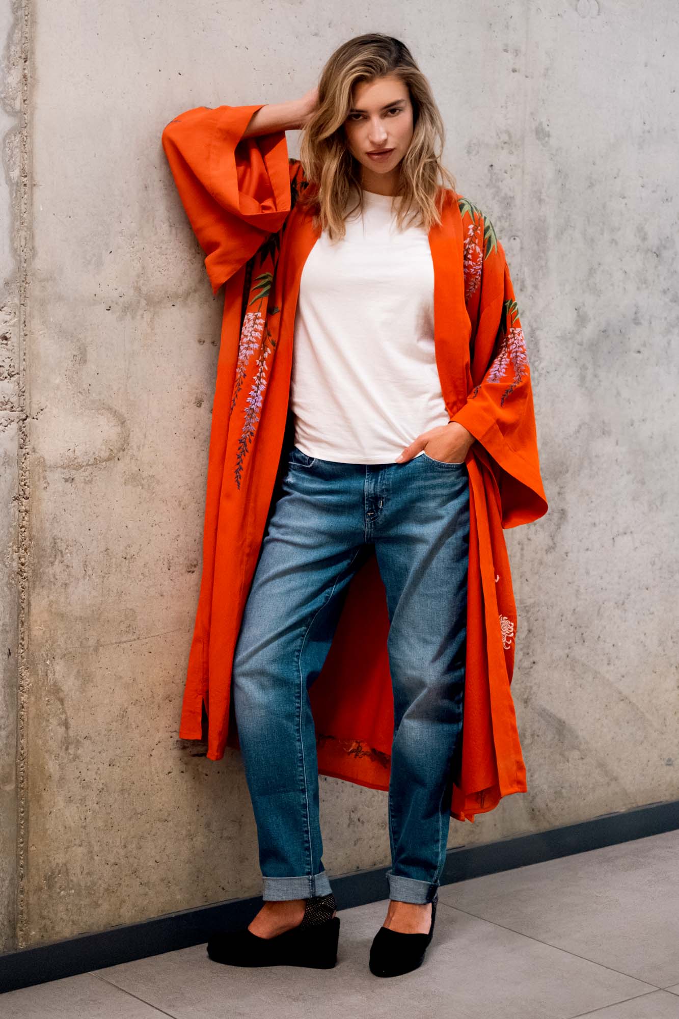 Model styles terracotta kimono robe embroidered with colourful wisteria and chrysanthemums over denim shorts and a black t-shirt