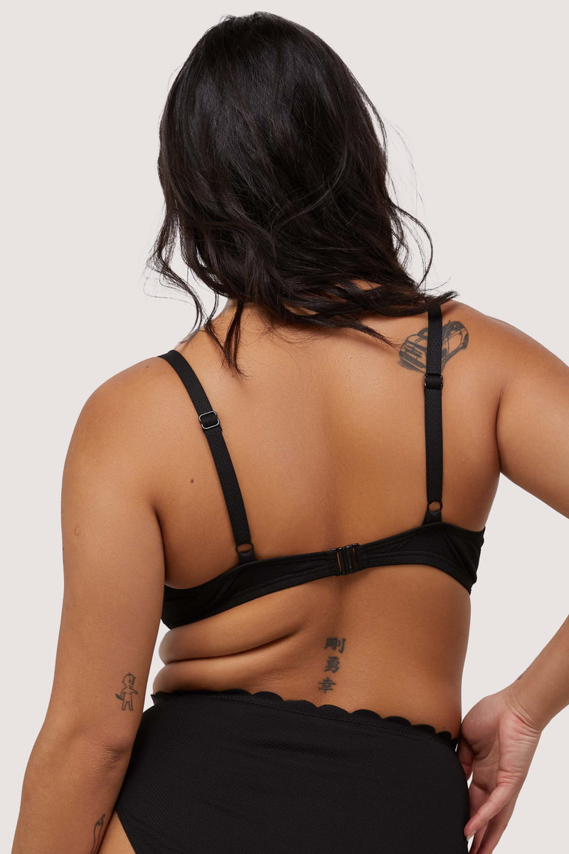 model shows adjustable shoulder straps and hook and eye fastening back of black scalloped bikini top