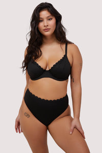 model wears black scalloped underwire bikini top and high waist bottoms swimwear set