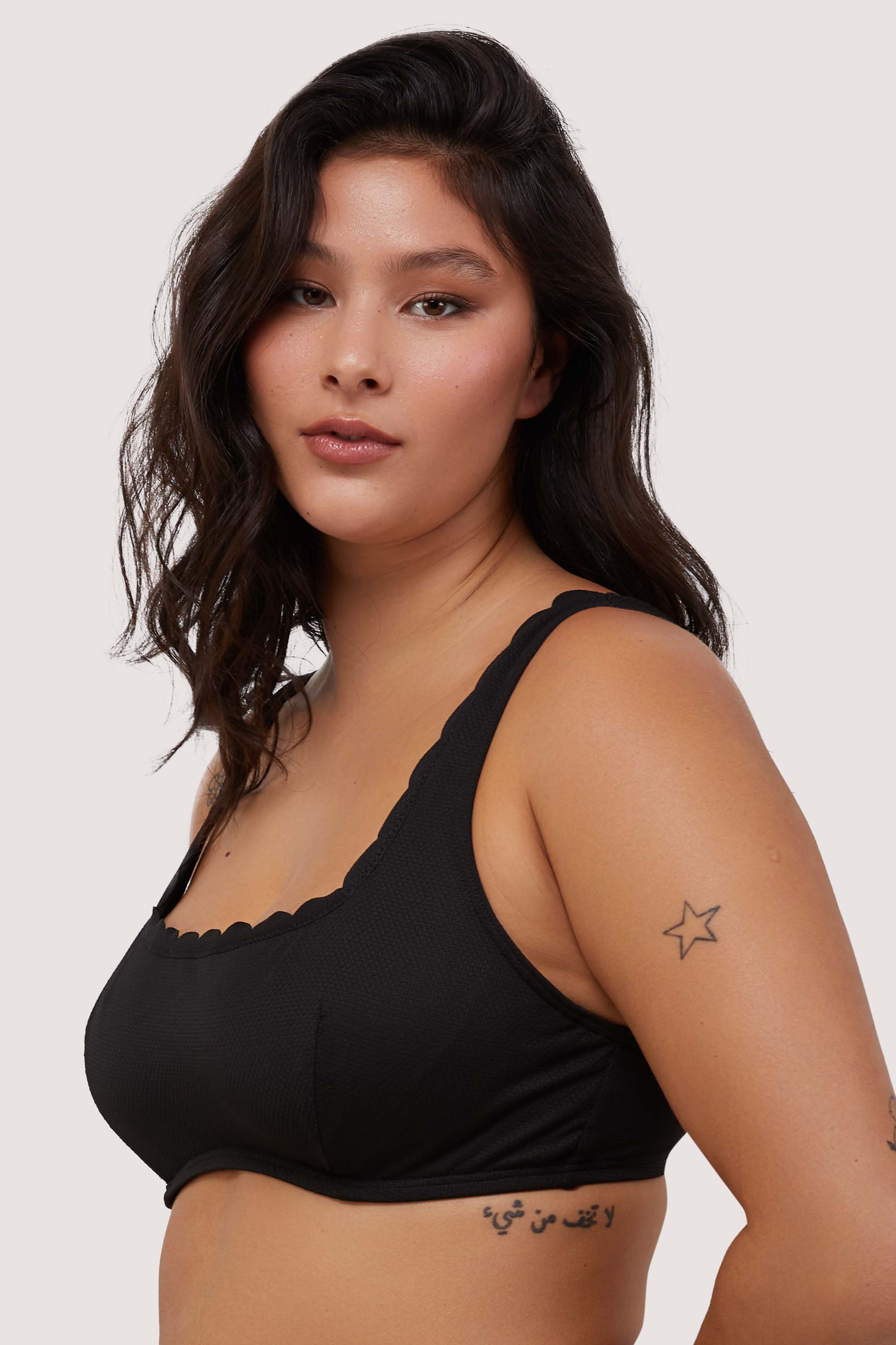 model wears black scalloped underwire balconette bikini top with thick shoulder straps