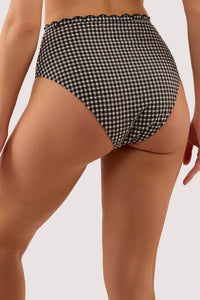 Model shows the back of a margot black & white gingham scallop trim high waist bikini briefs featuring lined gusset.
