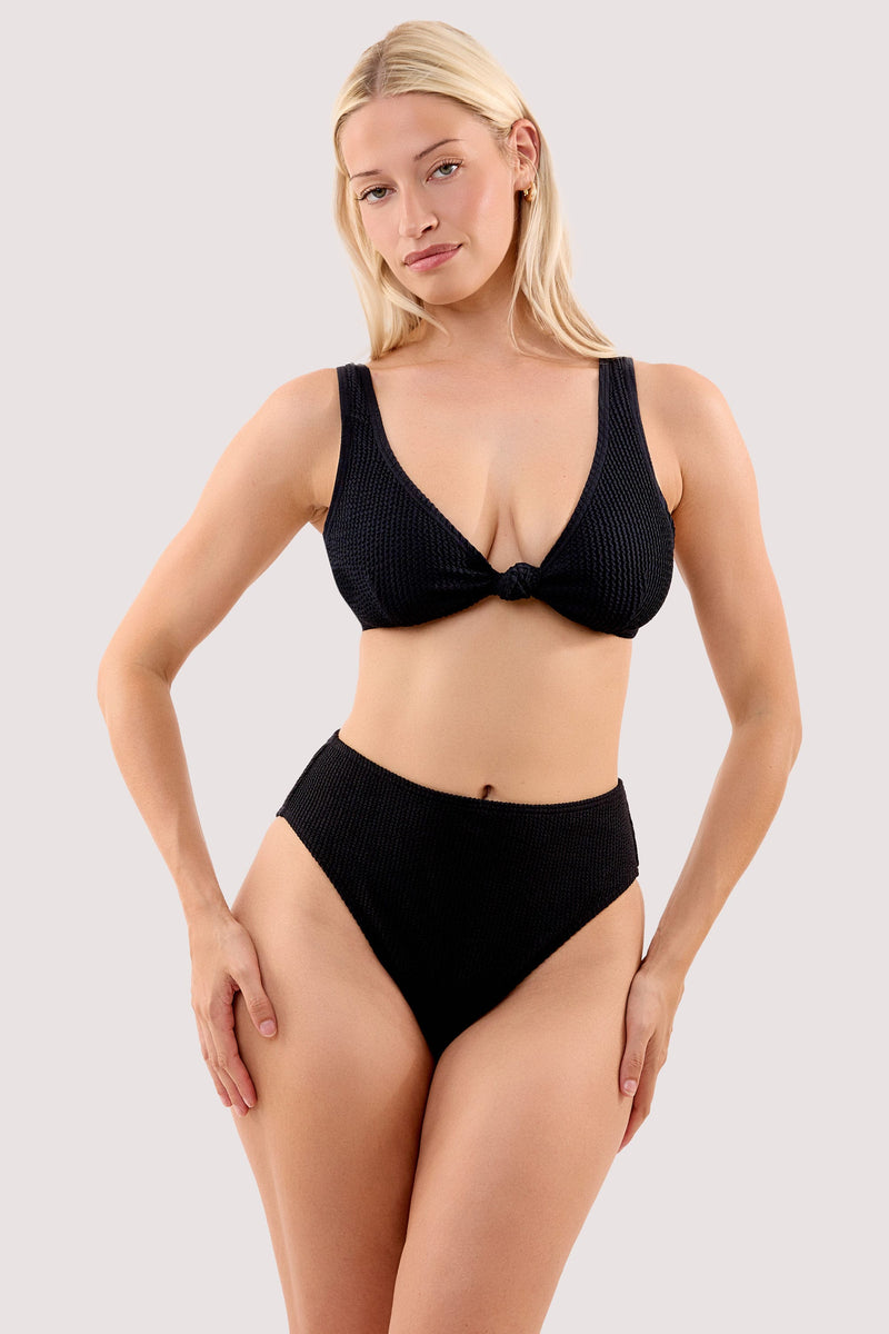 Model wears a selene black crinkle knot front bikini top with a matching high waist bikini bottom.
