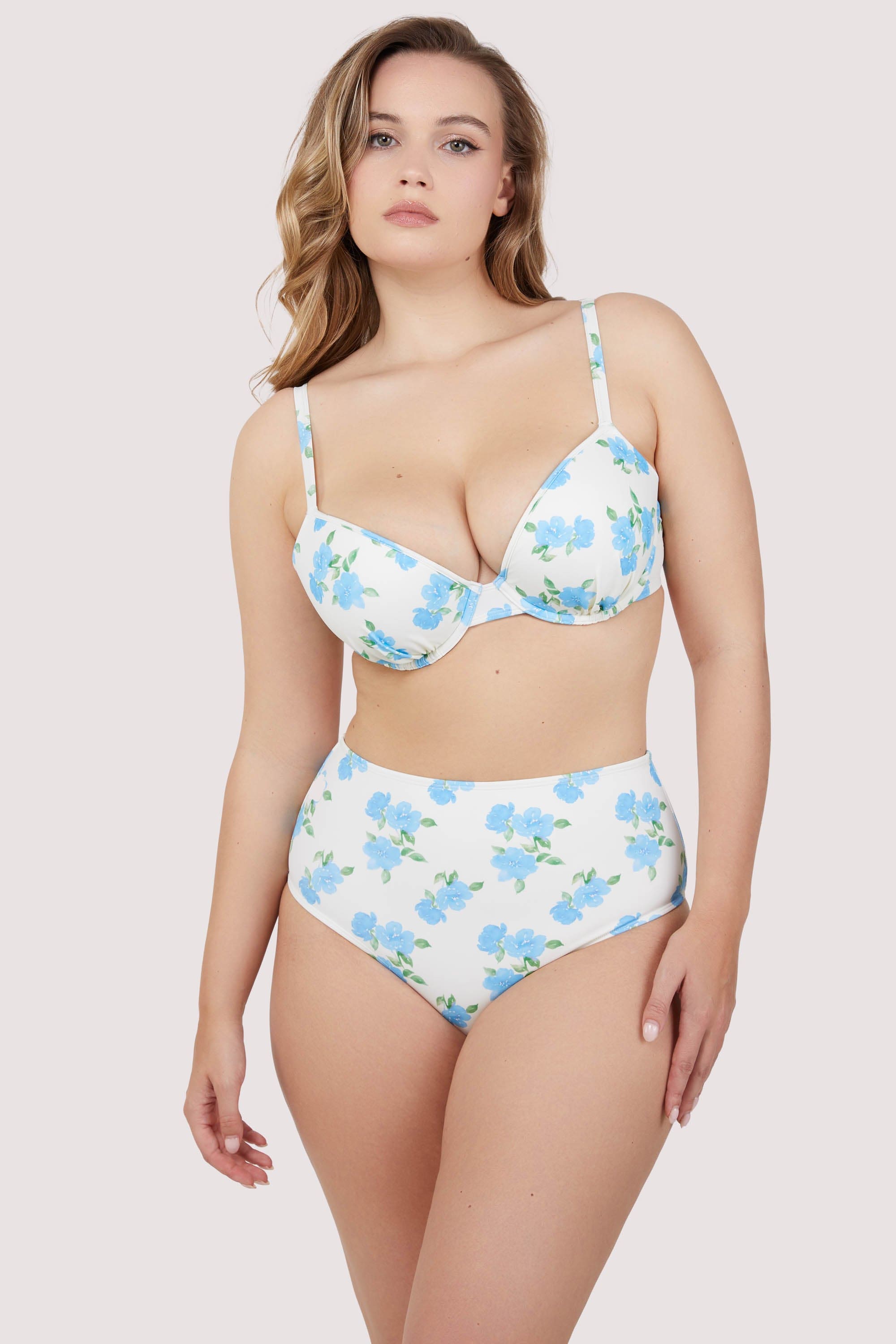 Model wears blue floral plunge foam cup bikini top and high waist bikini bottom set