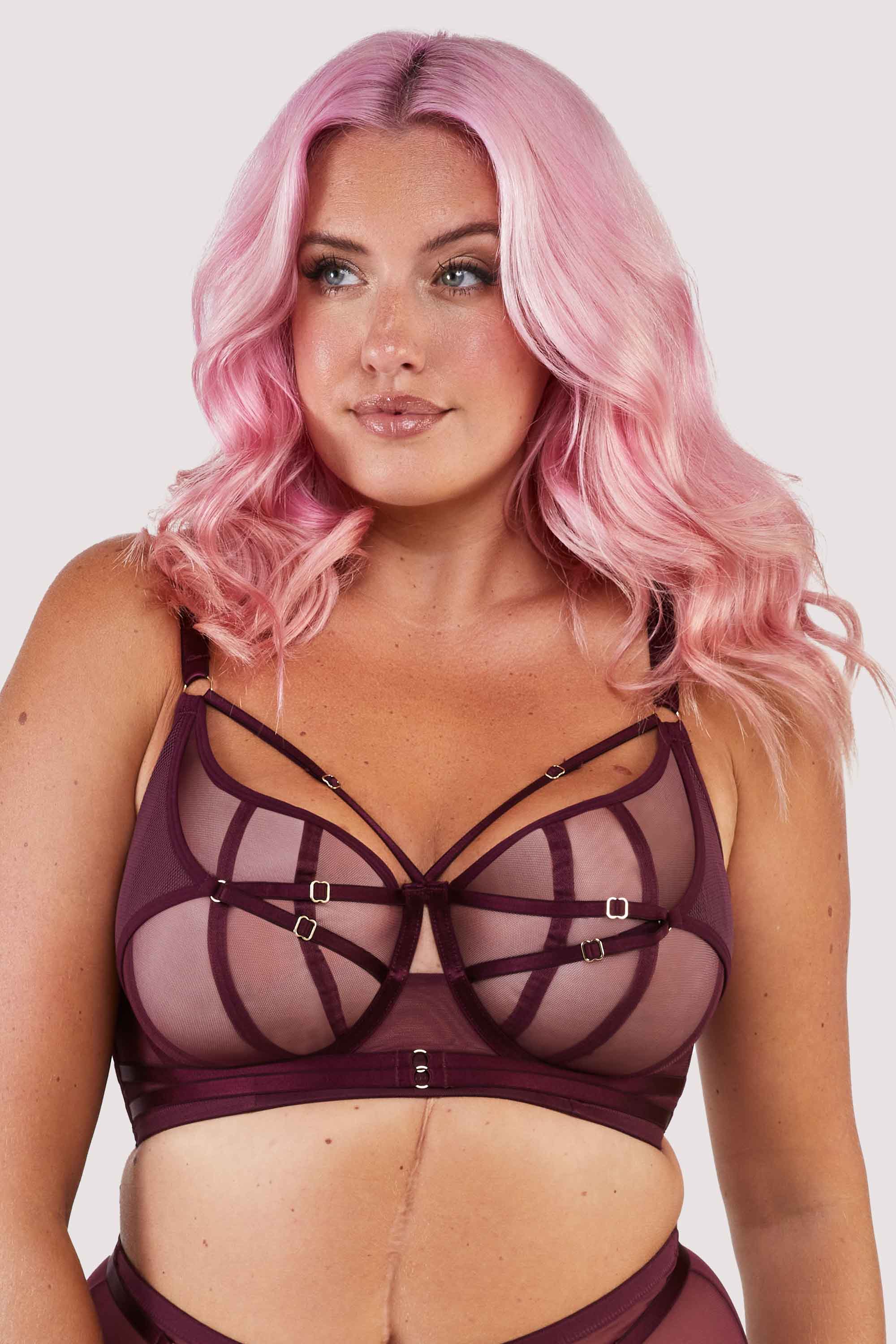 Harness style bra with mesh overlay and visible gold hardware in a deep wine red/purple.