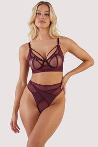 Dark purple-red mesh bra with strap detailing over the bust and visible gold hardware. Paired with matching thong.