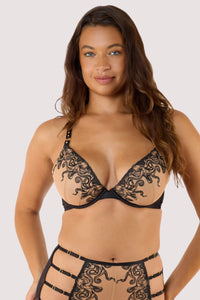 Model wears a octopus black embroidery plunge bra, showcasing intricate black embroidery on nude mesh fabric.
