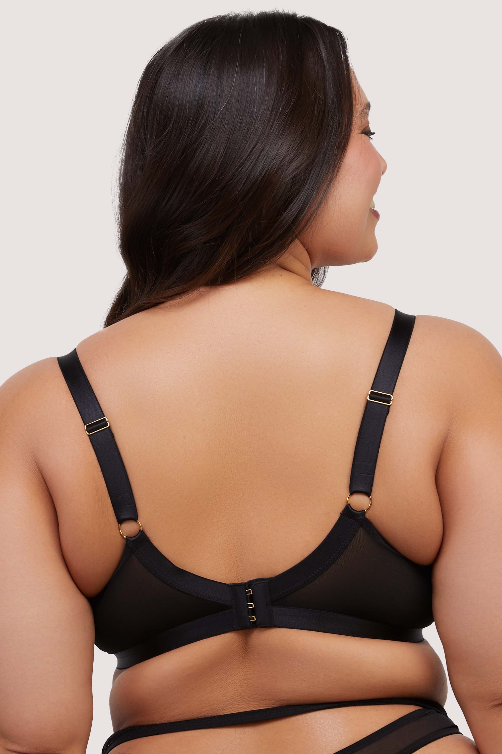 Model shows adjustable shoulder straps and hook and eye fastening back of sexy black bra