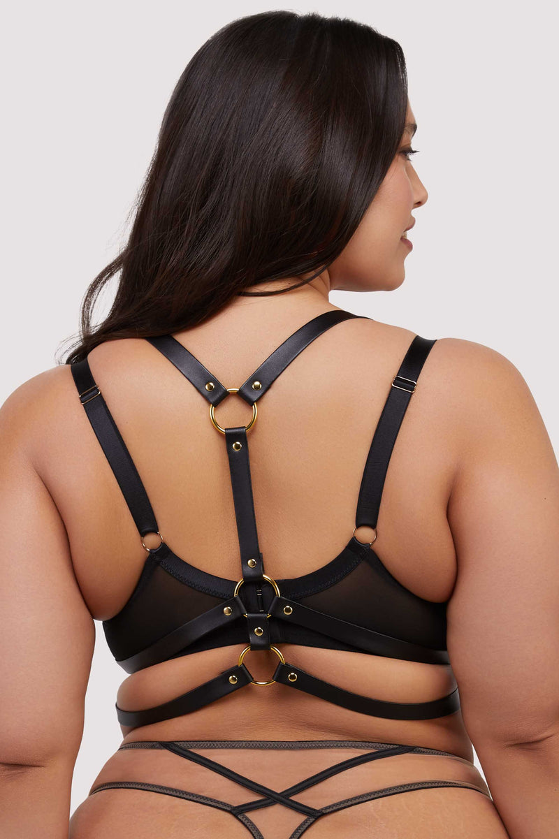 model shows back of black chest harness with gold rings
