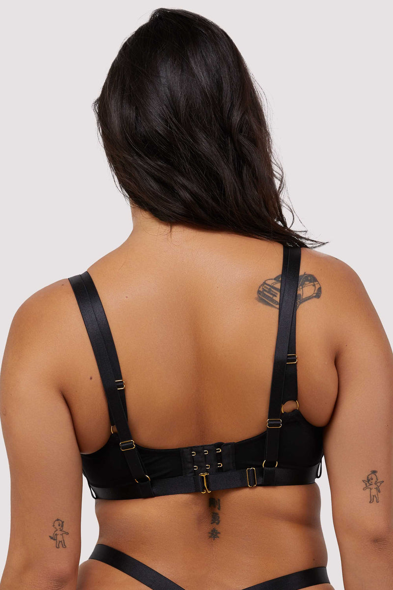 Model shows back of black balcony bra with hook and eye fastener, adjustable shoulder straps and swan clip harness closure