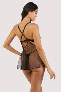 Back view of a black babydoll dress with lace and peephole cutouts on the bust and a flowing mesh dress with matching thong.
