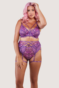 4 strap suspender with purple straps over the stomach, hips and thighs, worn with a matching bra and thong.
