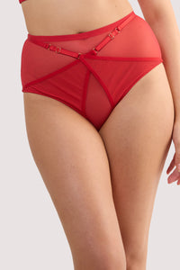Model wears a eddie ruby red crossover high waist brief with ruby red mesh and fishnet panels and full brief style.