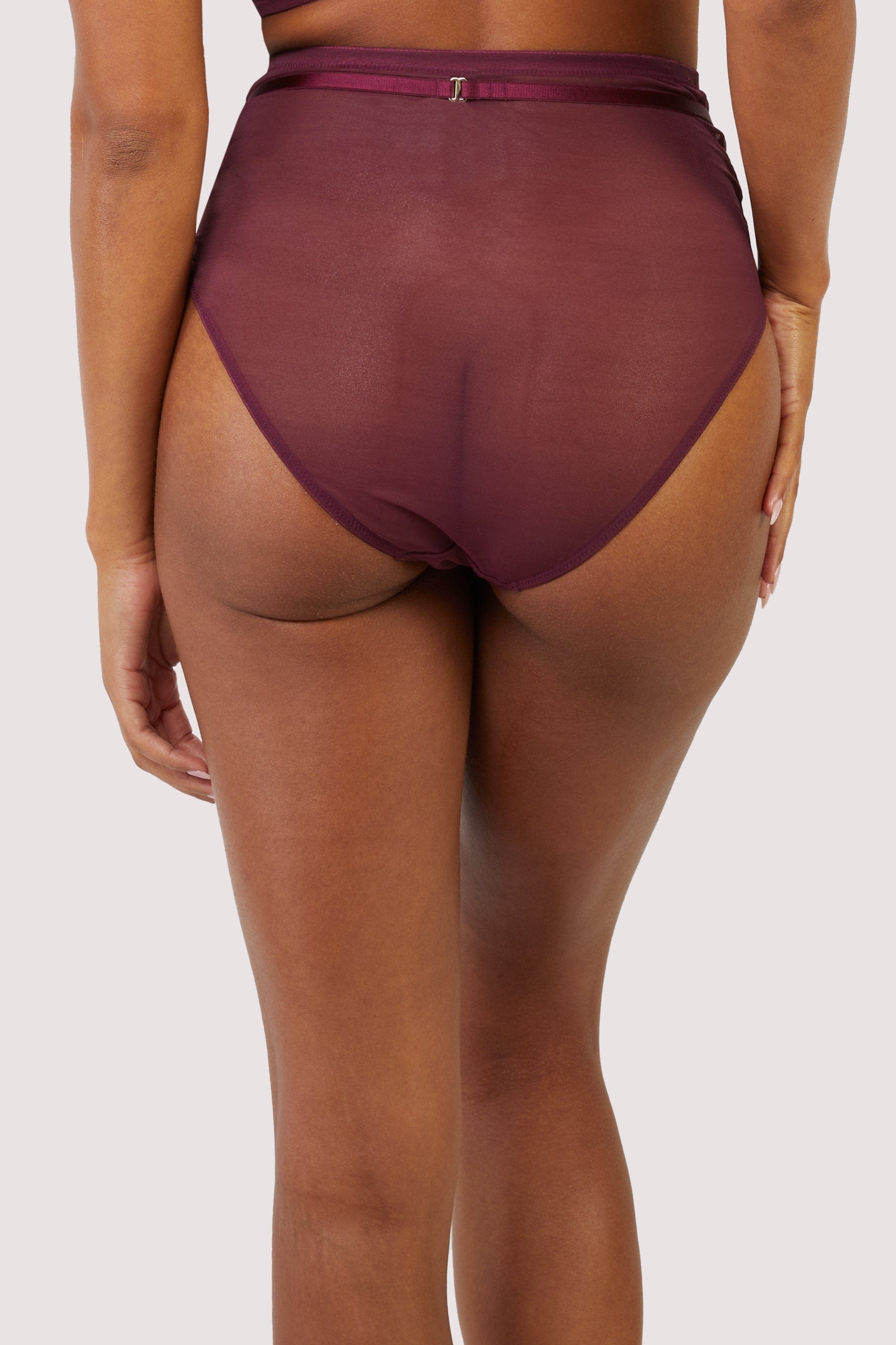 Dark purple-red mesh brief with visible gold hardware and crossover panelling across the front.