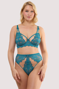 Model wears a teal eyelash lace high waist thong with velvet bow with pearl charm and nude mesh with teal eyelash lace panels, with a matching balconette bra.