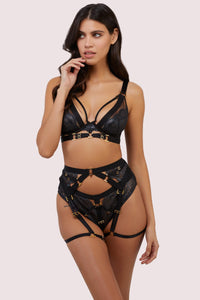 model wears black lace lingerie set with thigh harness suspender