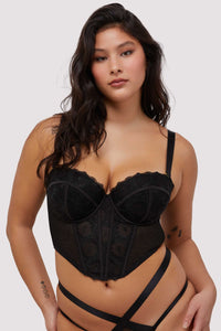 Model wears black embroidered mesh boned  bustier with removable shoulder straps and underwire cups