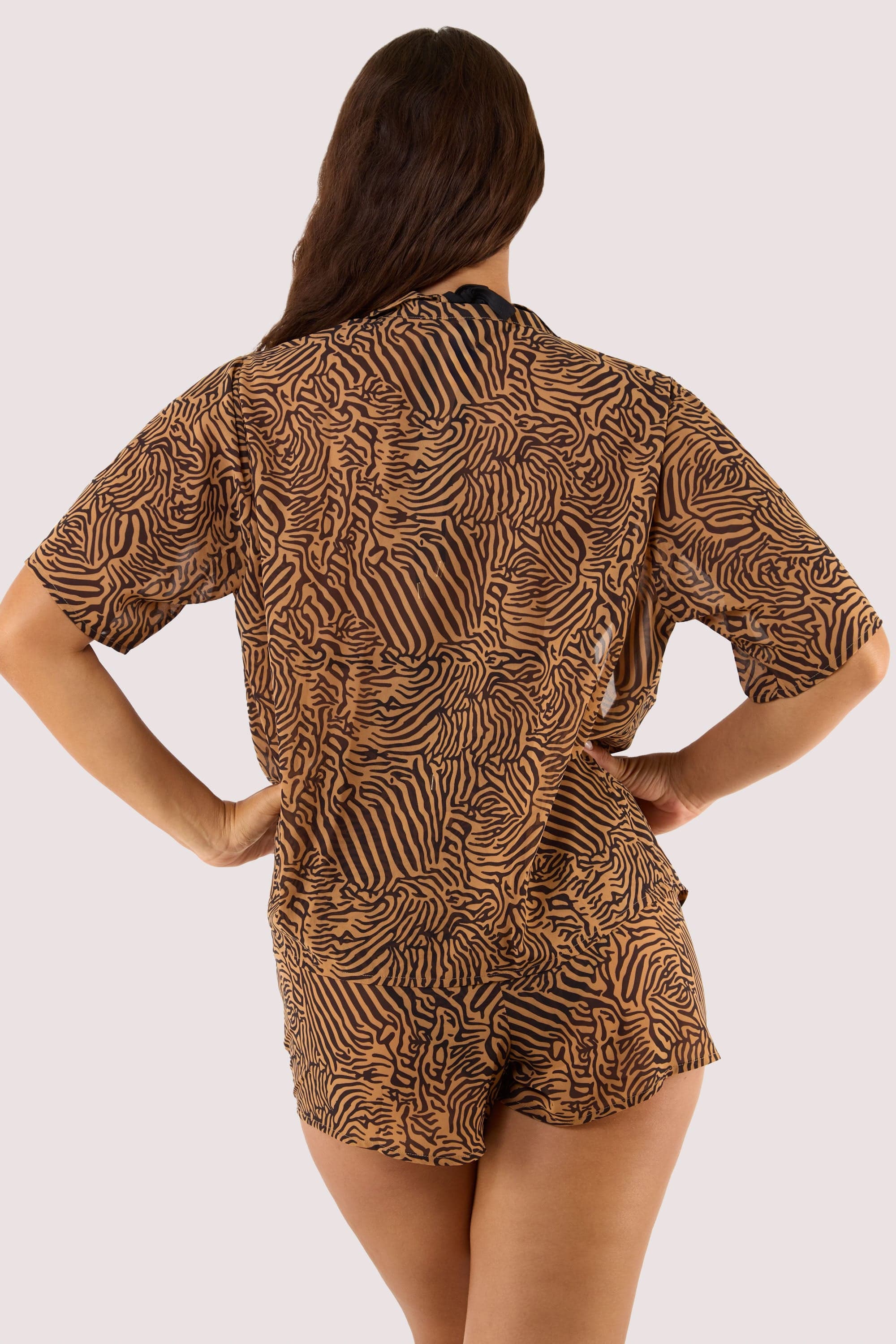 Model Back view of tiger print georgette beach shirt and shorts.