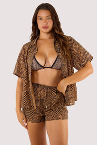 Model in tiger print beach co-ord set with open shirt and matching shorts.