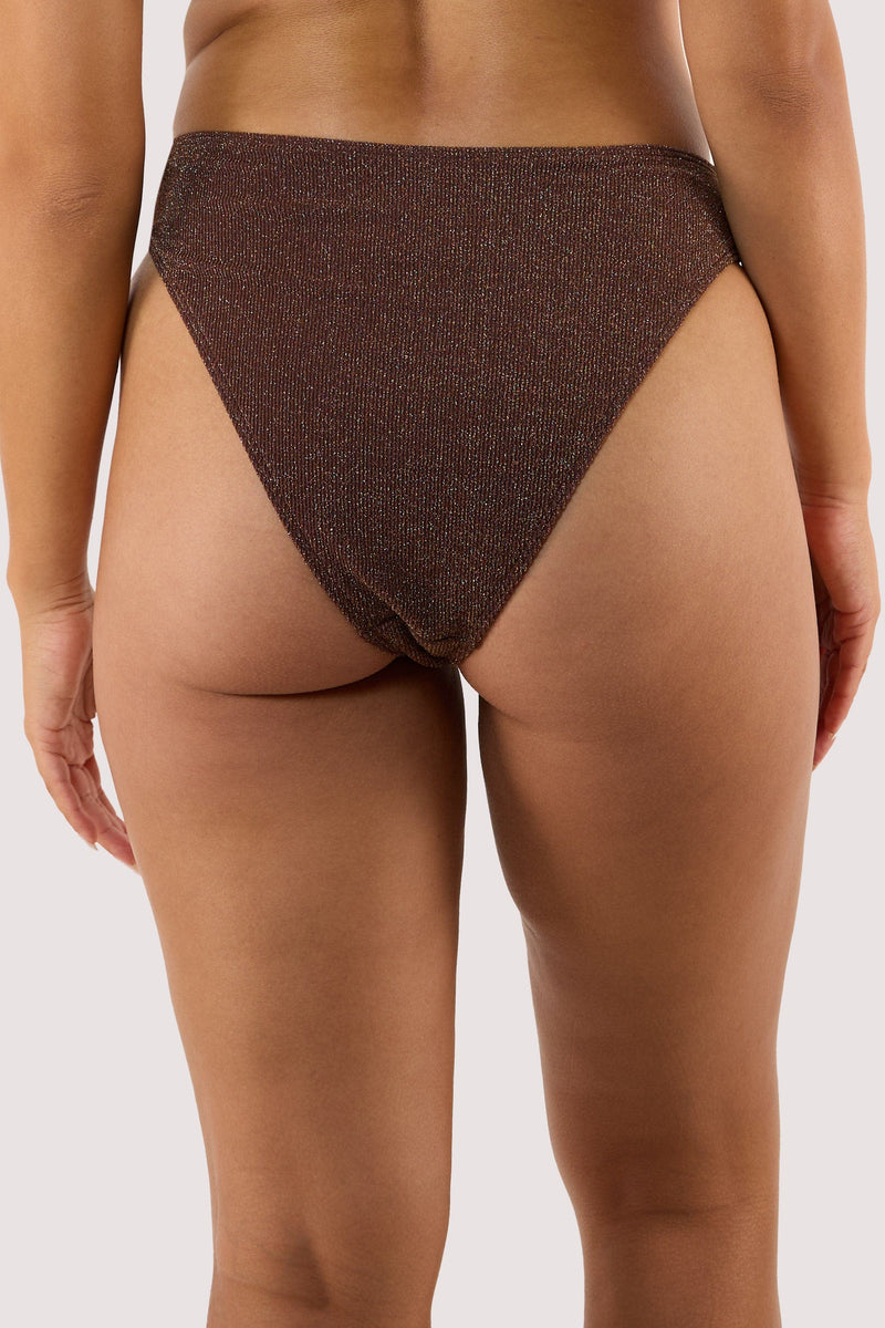 Model Back view of high-leg bikini bottoms in shimmering bronze fabric with a cheeky cut