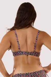 Model Back view in a black ditsy-floral bikini with adjustable straps and a metal clasp fastener.