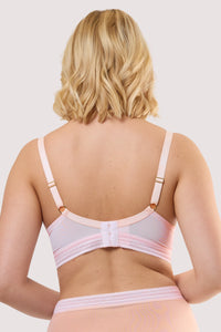 Model shows the back of a icon blush pink microfiber moulded cup bra with adjustable shoulder straps and hook and eye fastener.