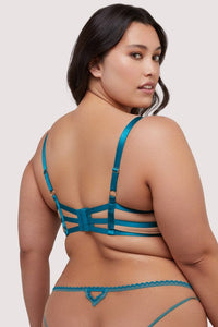 Model shows the back of a teal eyelash lace balconette bra with adjustable straps and hook and eye fastening back.