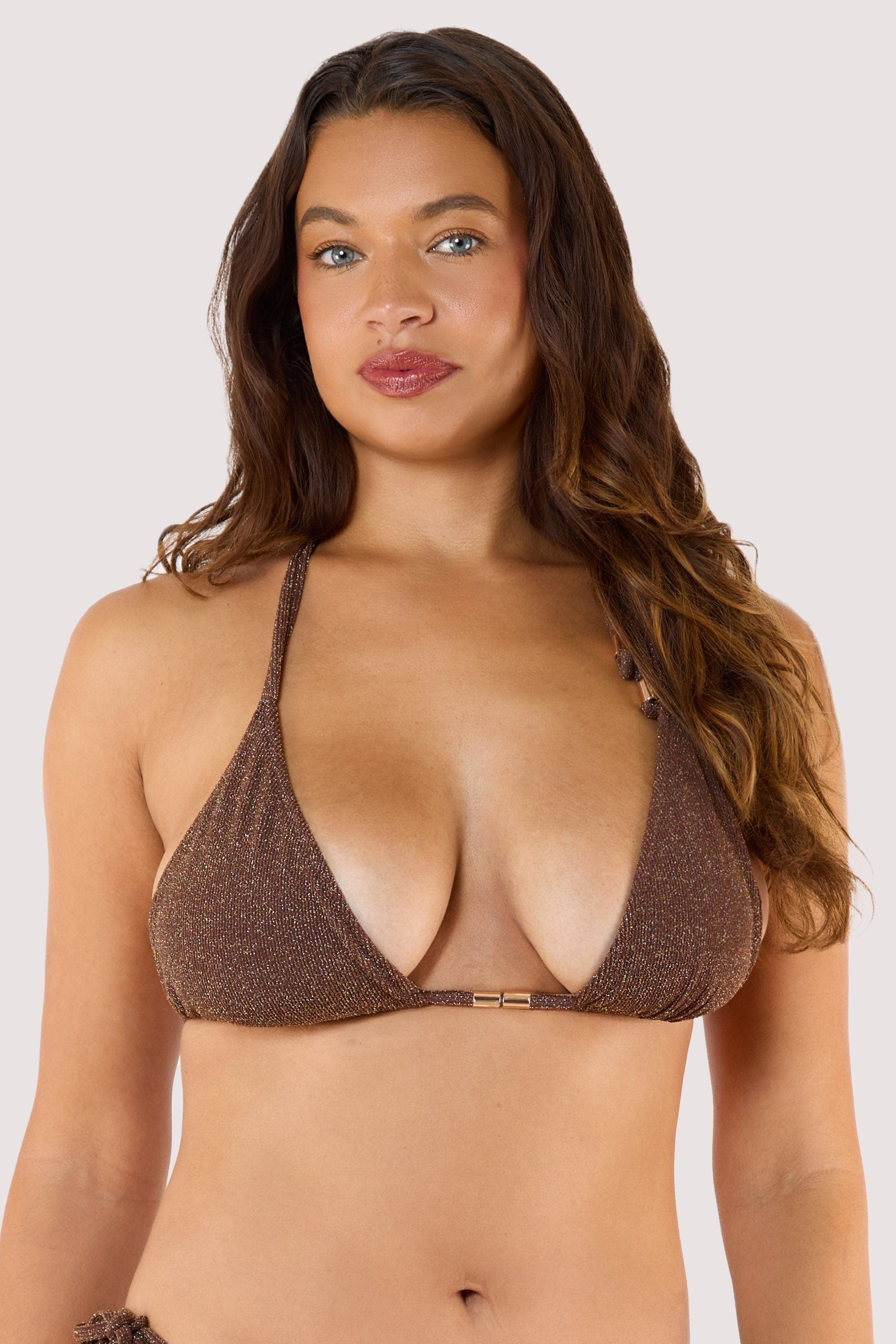 Model wearing shimmering bronze triangle bikini with tie-side bottoms