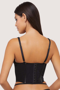 Model shows the back of a black vegan leather underbust corset with hook and eye fastening back.